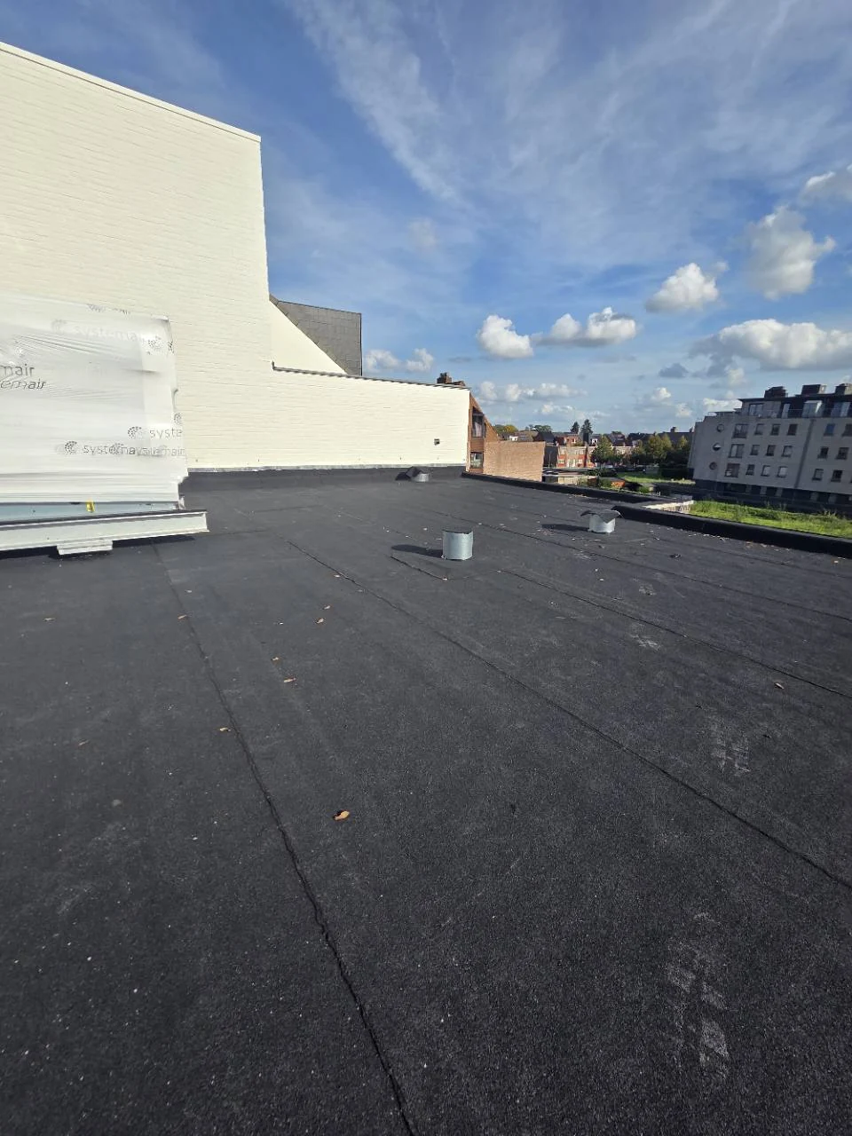 Aangeleverde werffoto van een ruim plat dak met bitumenafwerking.